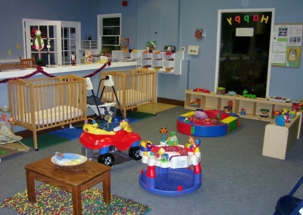 Nursery room with cribs, toys, and a chalkboard