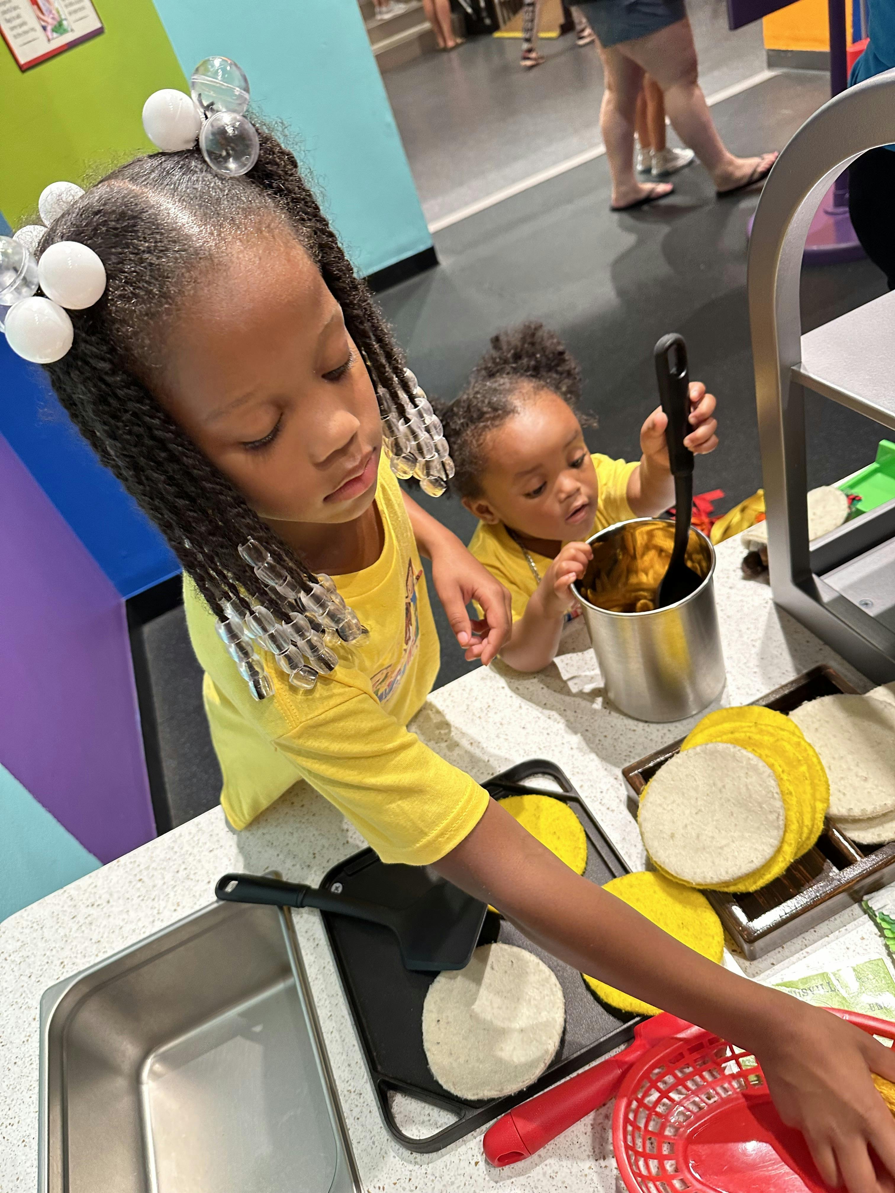 Child cooking with toy food, teen mixing something in a pot