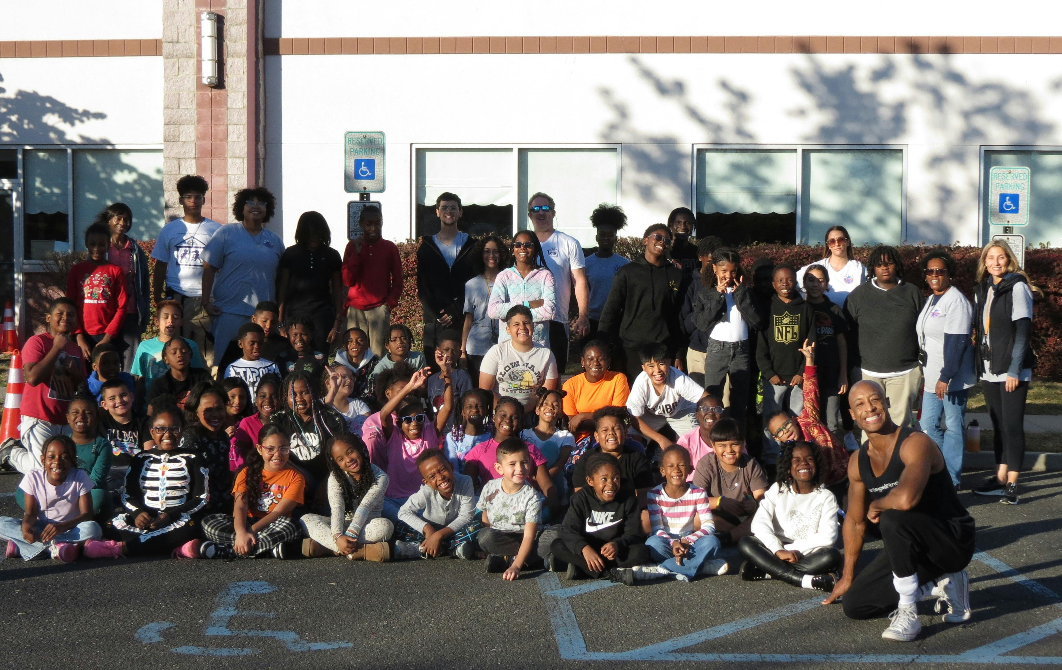 Large group of adults and children posing outdoors