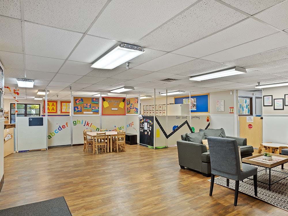 Classroom with play areas, a low table and chairs, and a small sofa seating area