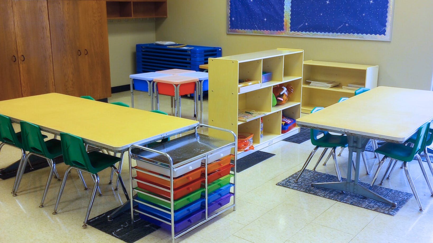 Classroom with tables, chairs, and storage shelves