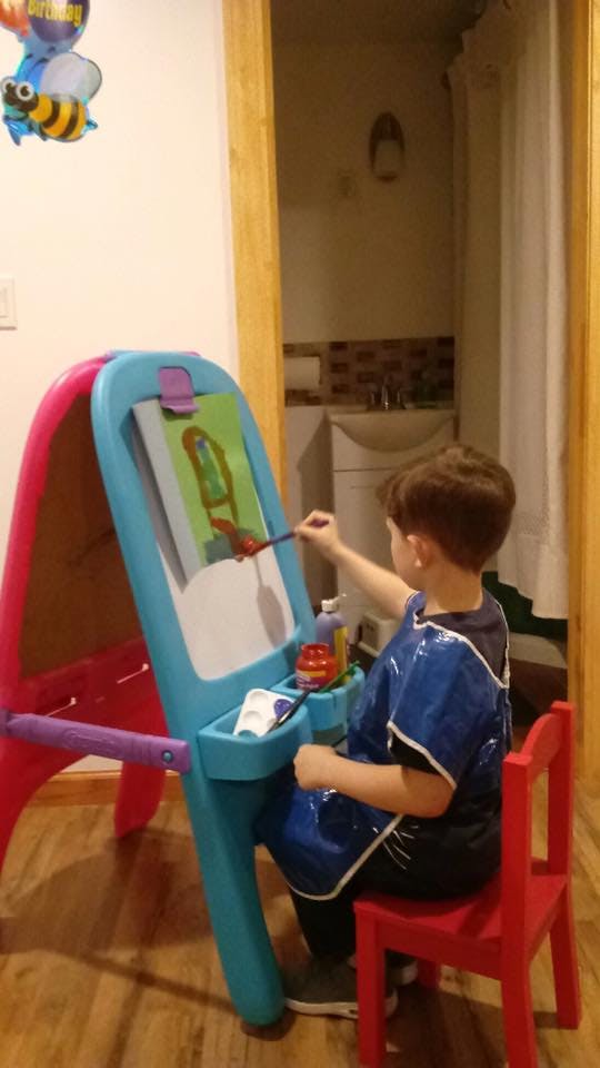 Child painting at an easel
