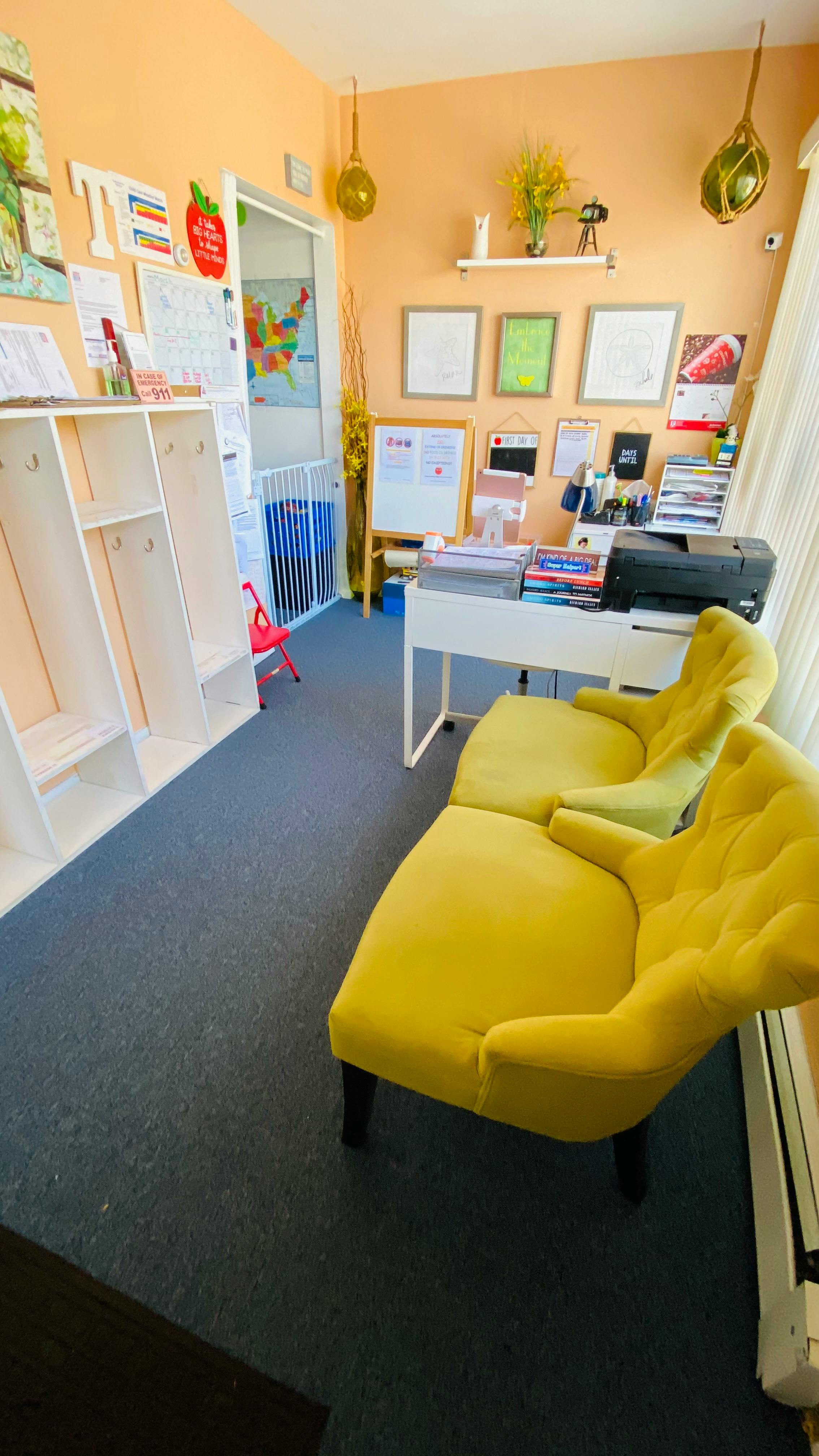 Classroom with yellow chairs, white shelves, and a desk