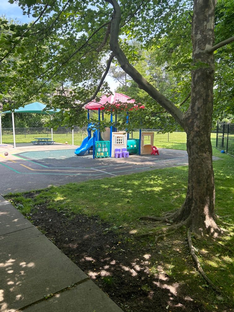 Playground with colorful play structures, slides, and shaded areas