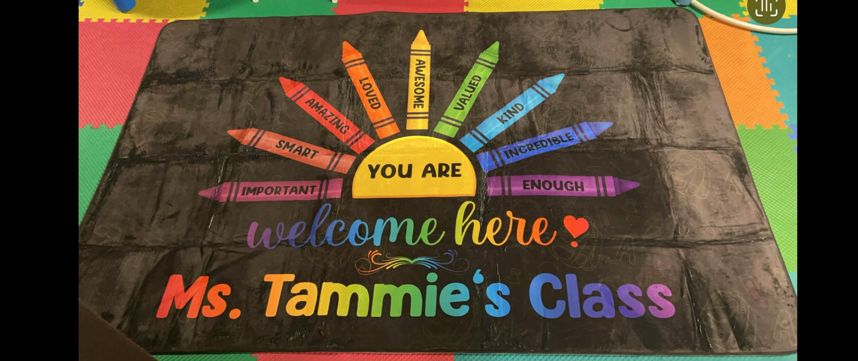 Black mat with colorful crayons and text "You Are Welcome Here Ms. Tammie's Class"
