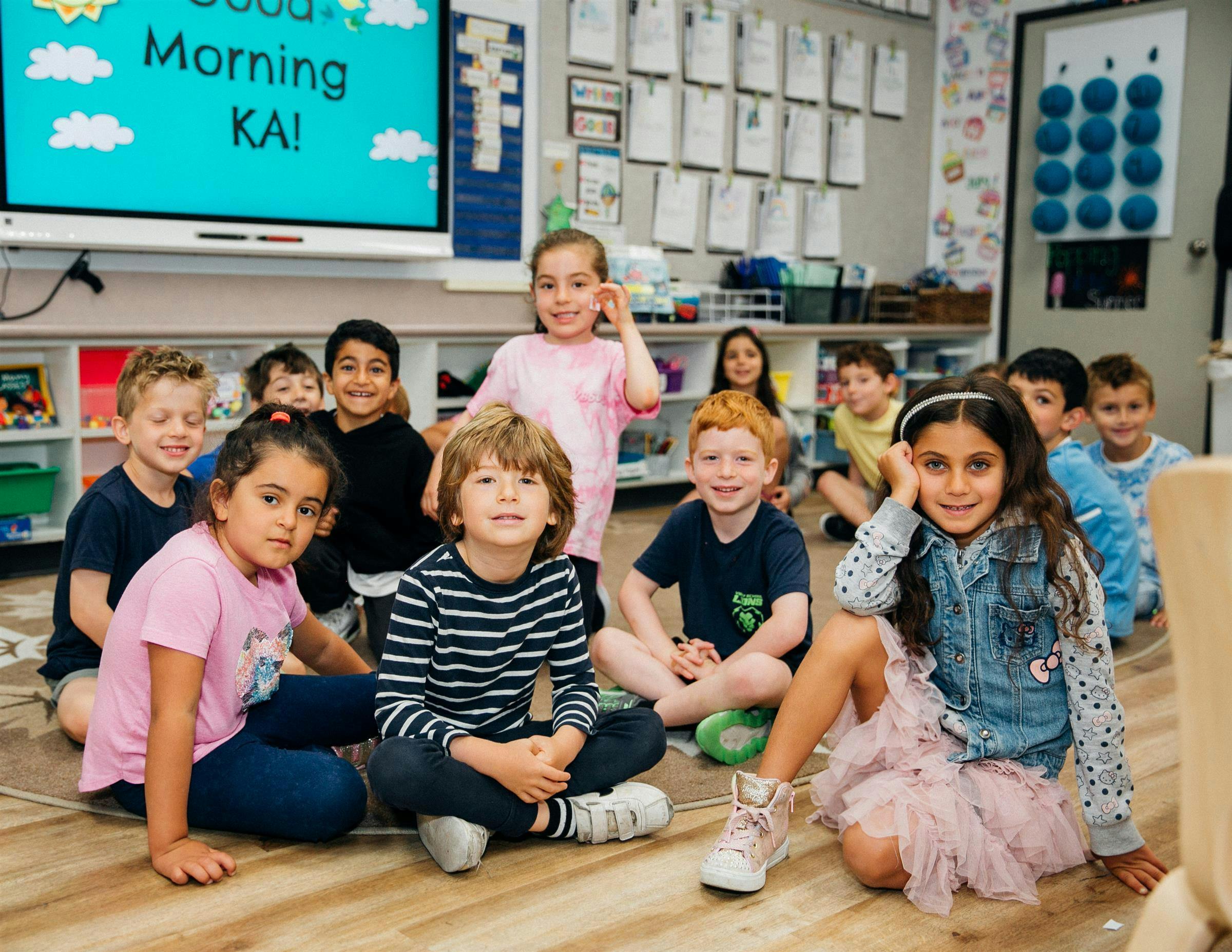Group of children sitting on the floor in a classroom