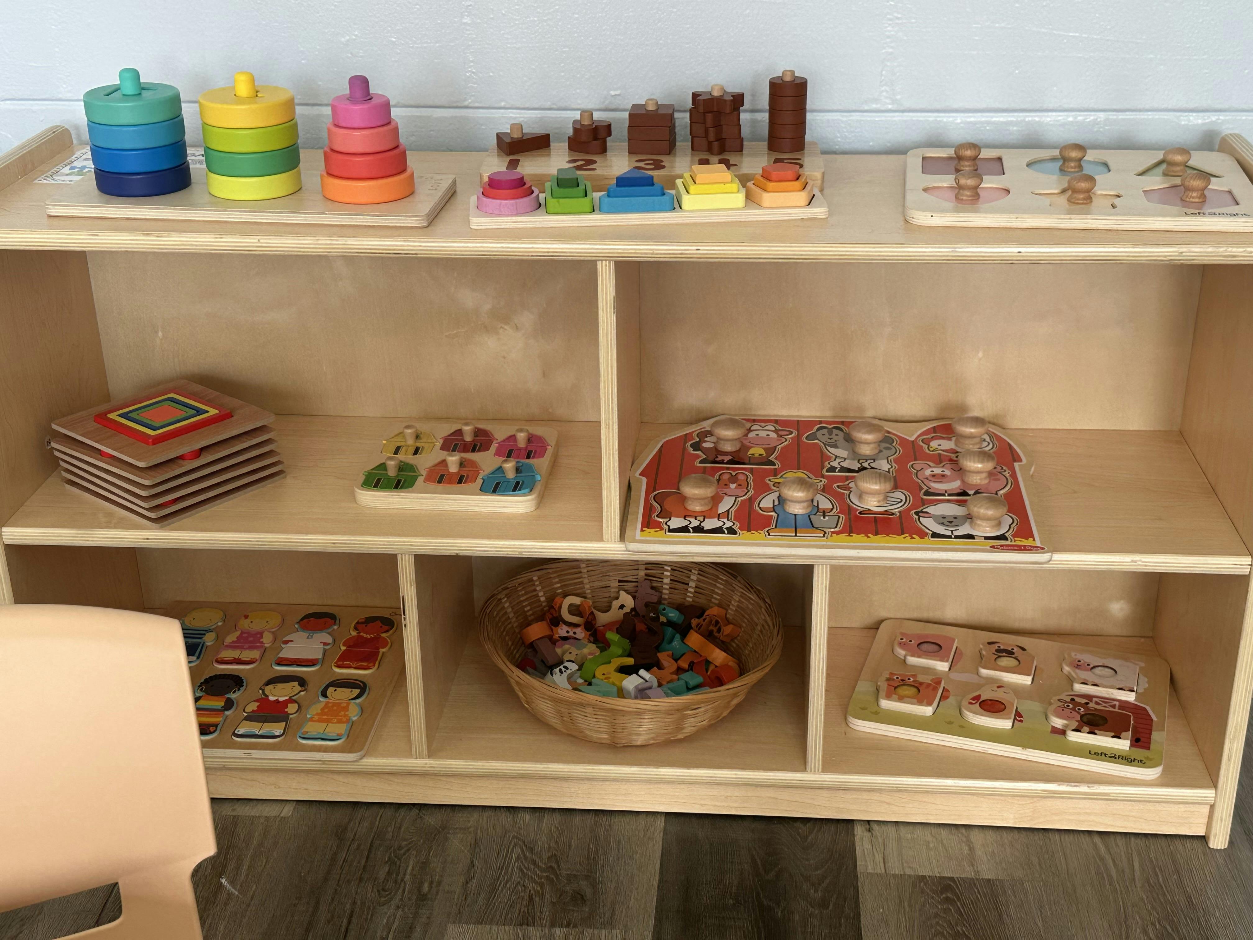 Wooden shelf with various children's puzzles and stacking toys