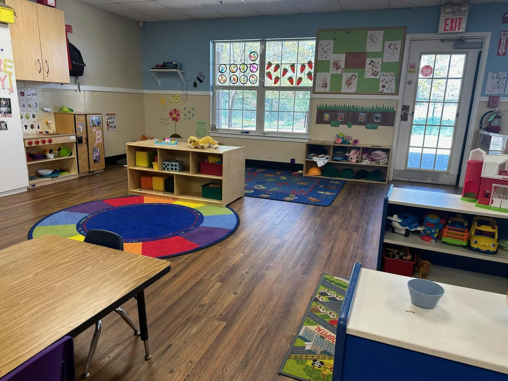 An empty early childhood classroom with toys and art on the walls