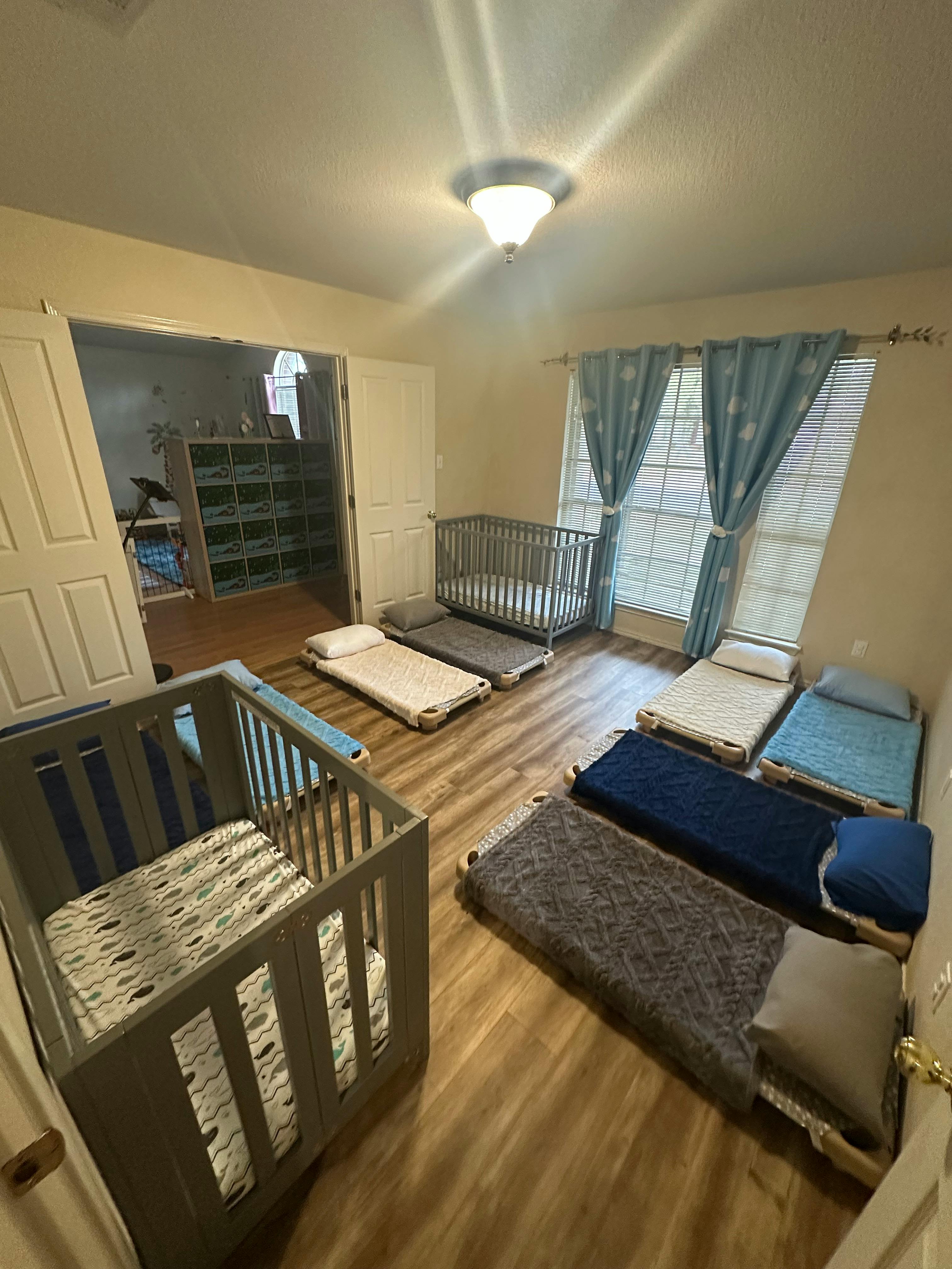 Room with multiple cots and two cribs