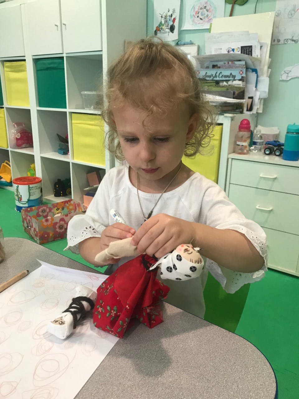 Child playing with a doll at a table