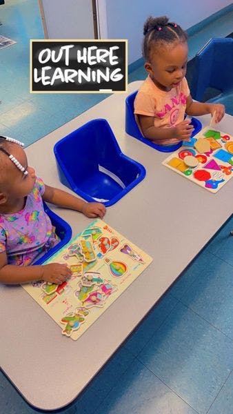 Two children playing with puzzles at a table