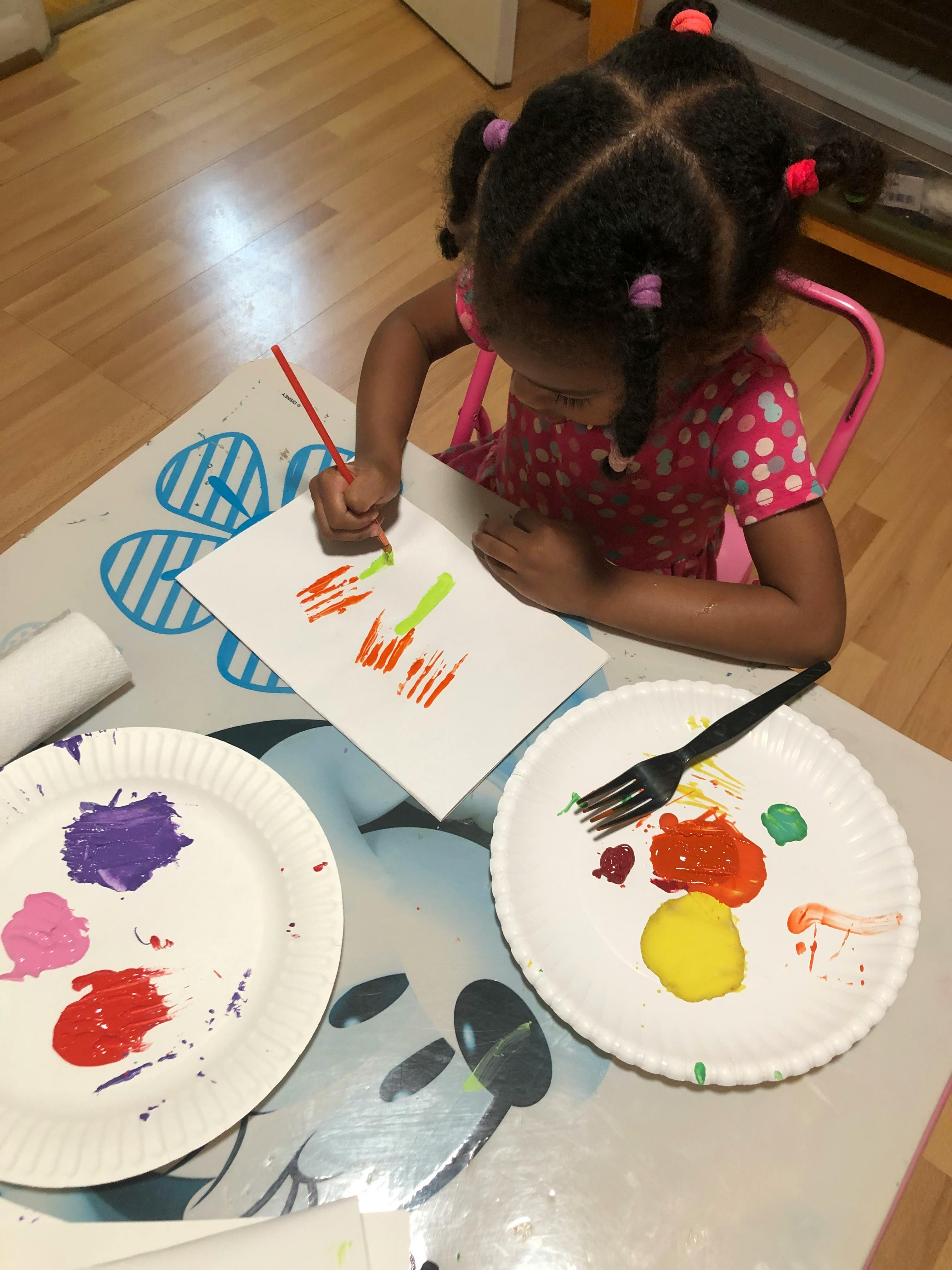 Child painting on paper with a brush