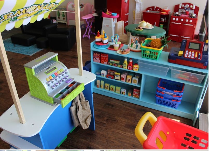 Play market with toy cash register and shelves of play food