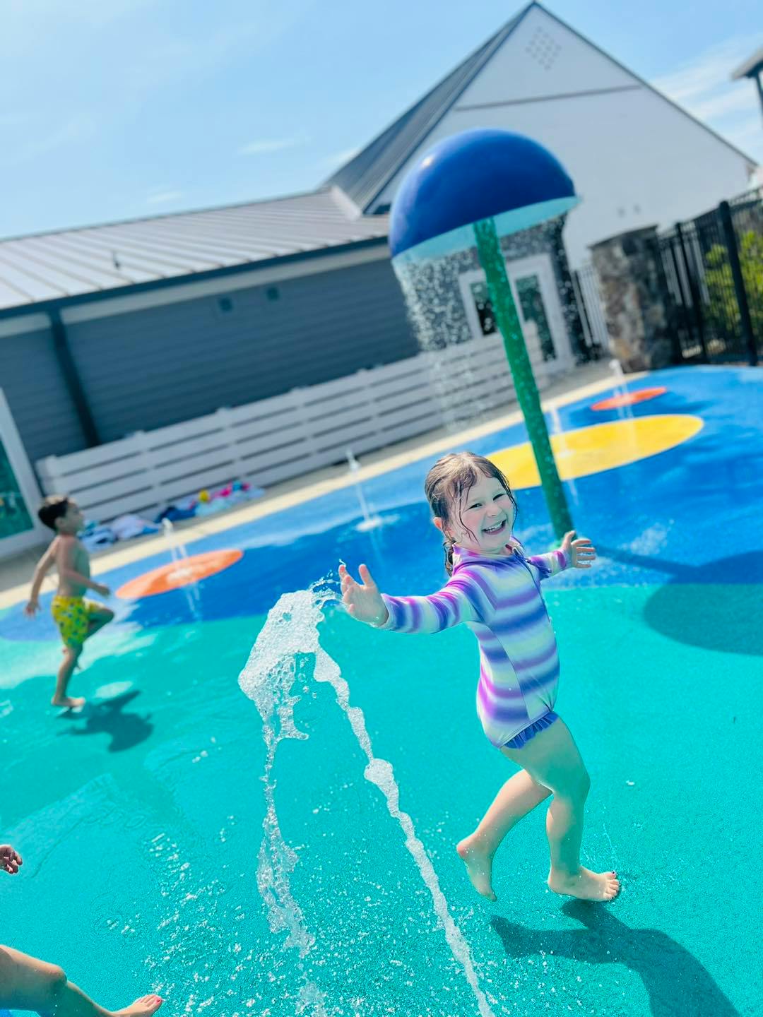 Child playing in a splash pad with water spraying