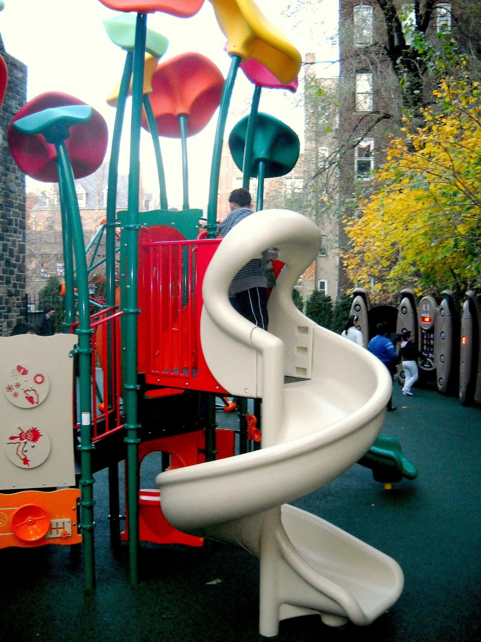 Child on a playground structure with a spiral slide