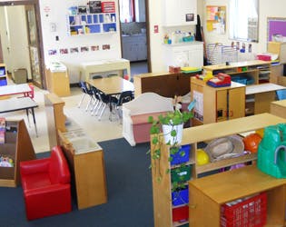 Empty classroom with tables, chairs, and shelves