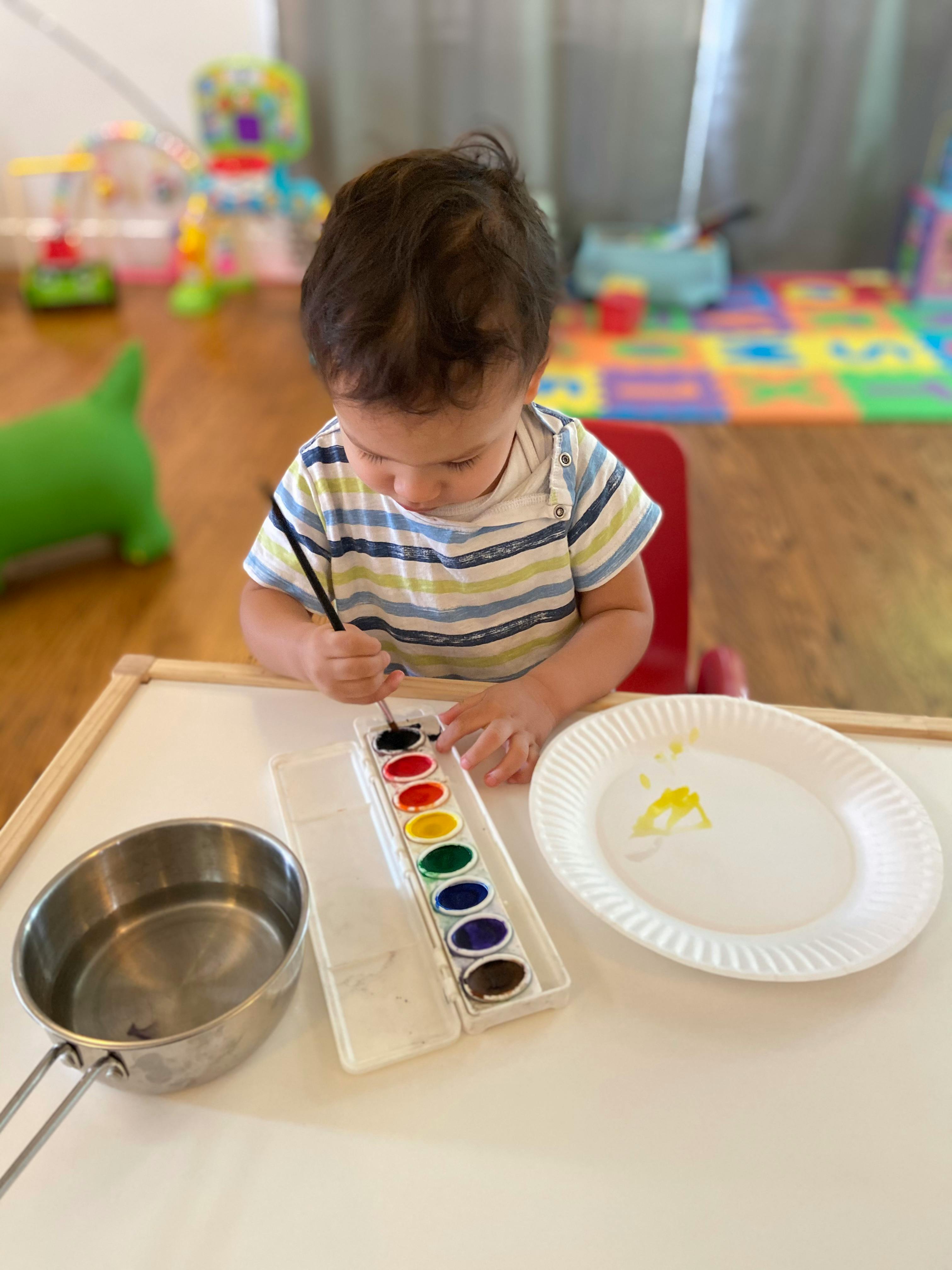 Child painting with watercolors at a table