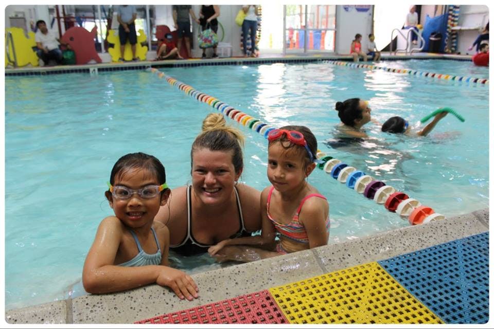 Adult and two children in a swimming pool