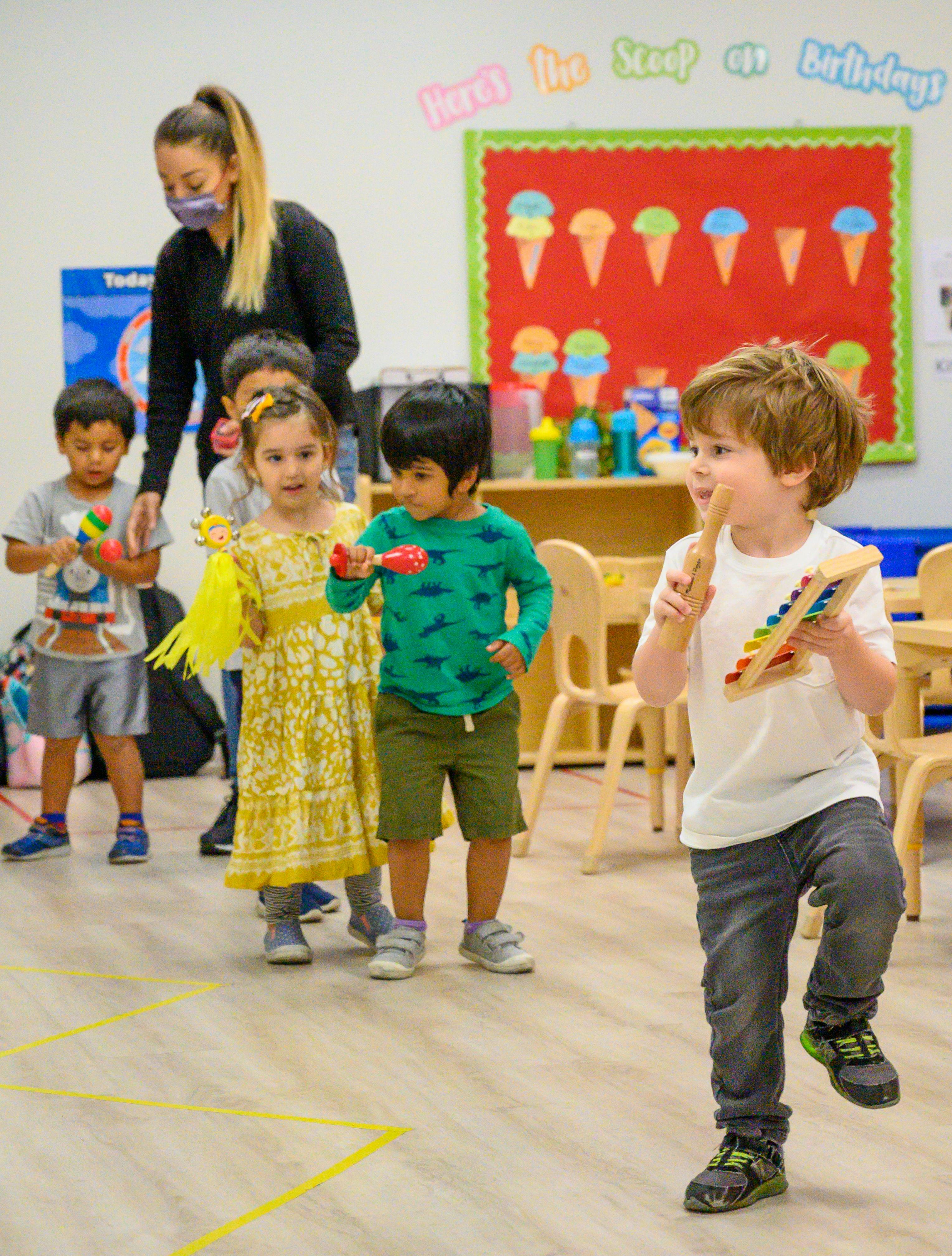 Adult and children playing with musical instruments in a classroom