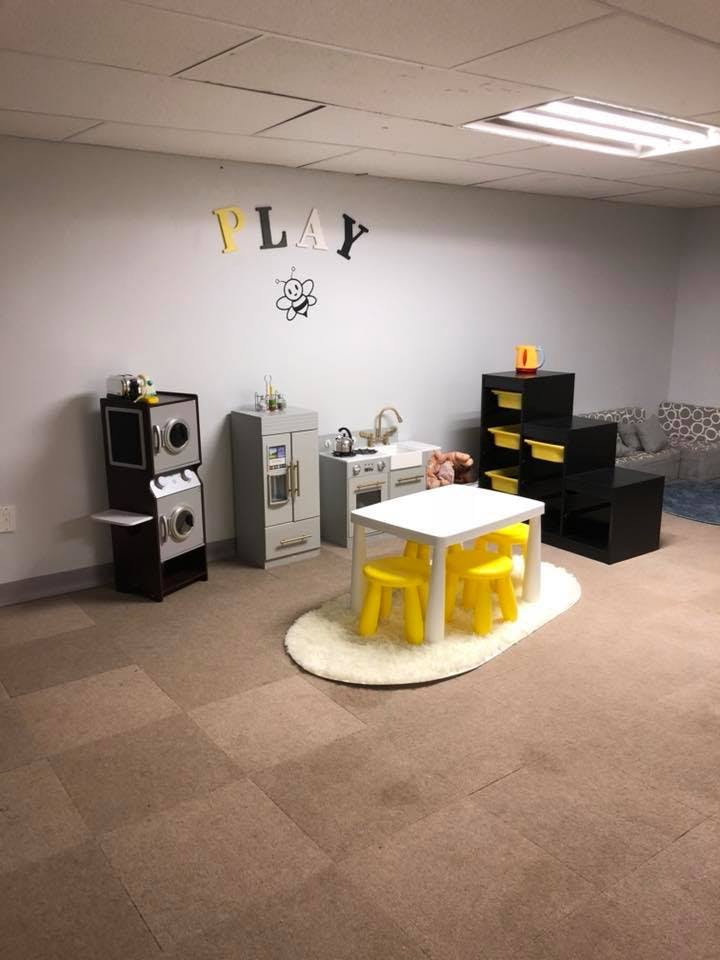 Children's play area with toy kitchen, washer and dryer, and small table with chairs