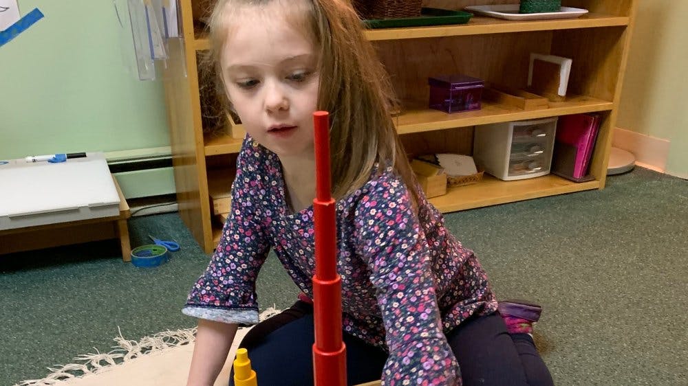 Child playing with a red stacking toy