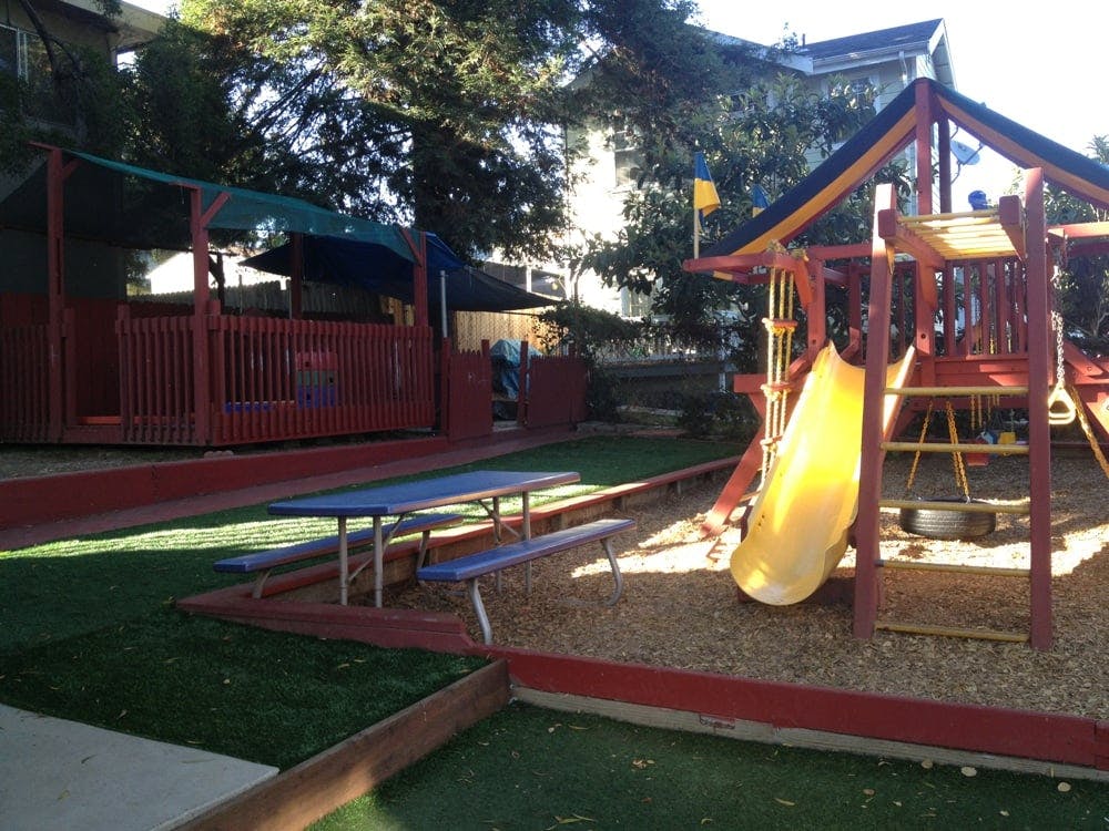 Outdoor playground with a yellow slide and picnic table