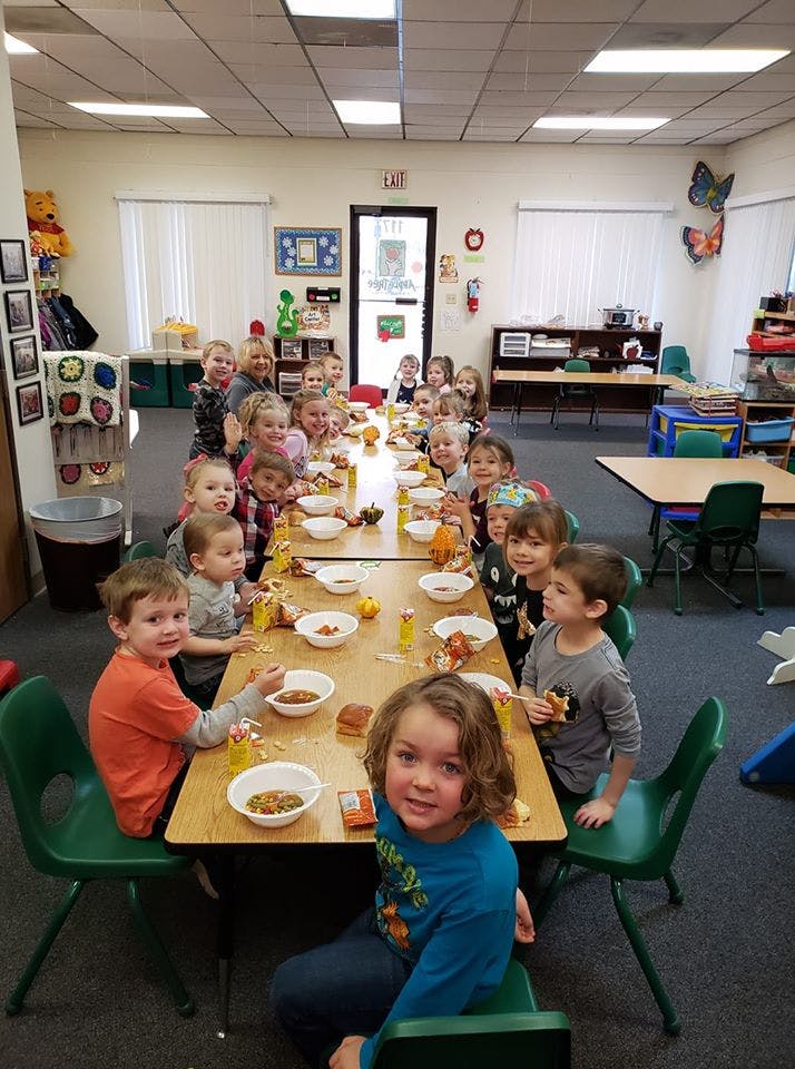 Children sitting at tables in a classroom