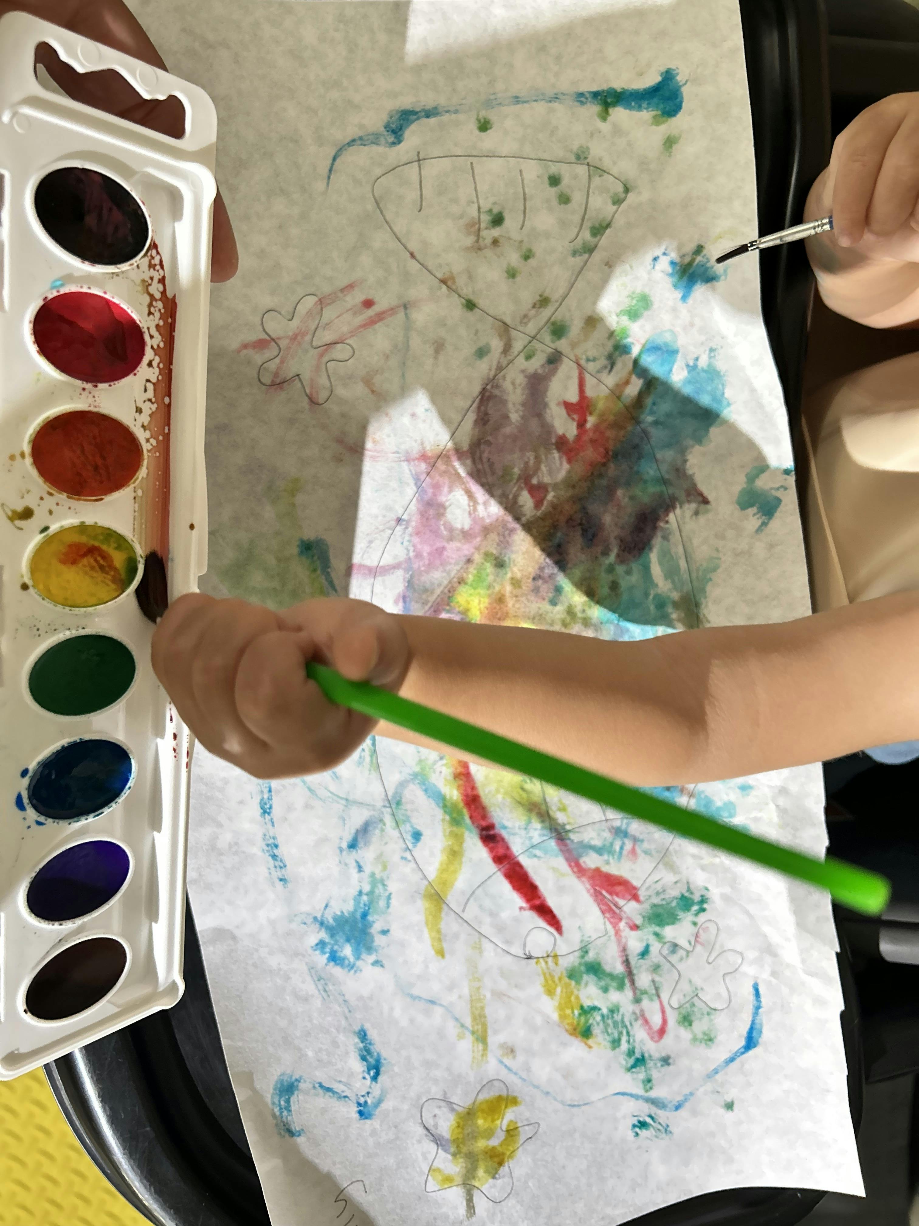 Child painting with watercolors on paper