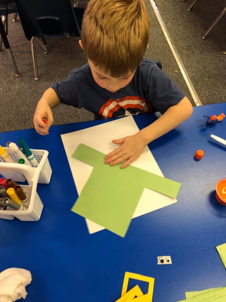 Child making a craft with paper and markers
