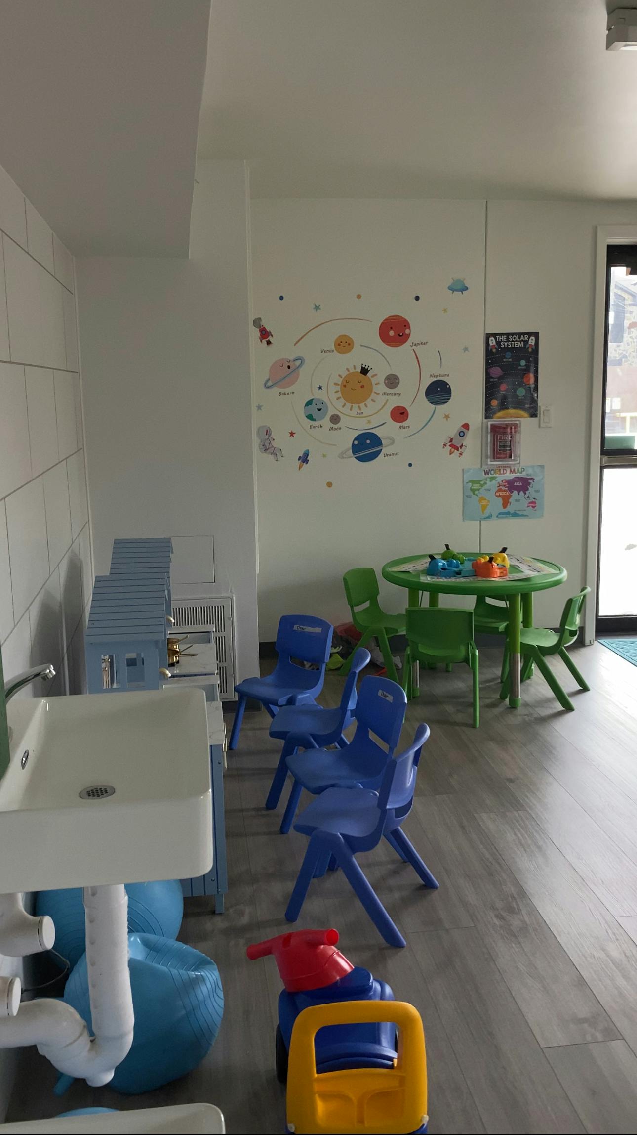 Children's play area with small tables, chairs, and a sink