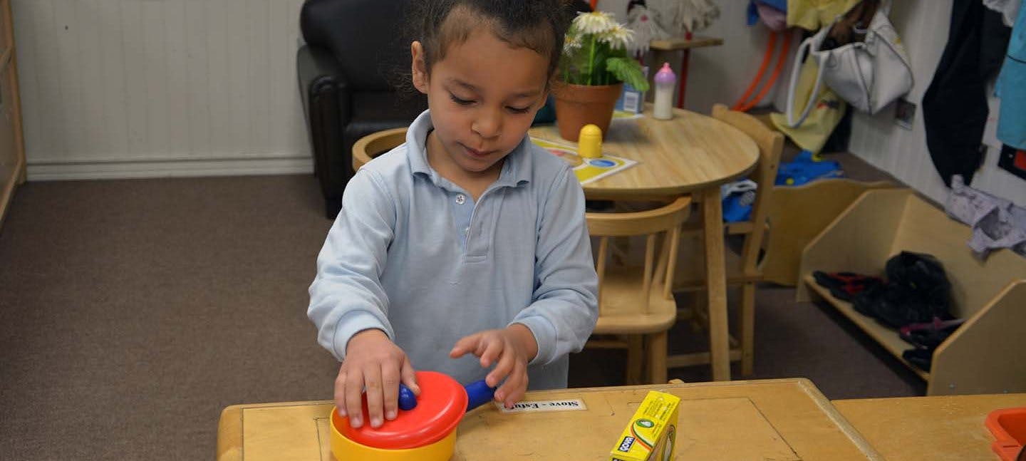 Child playing with a toy on a table