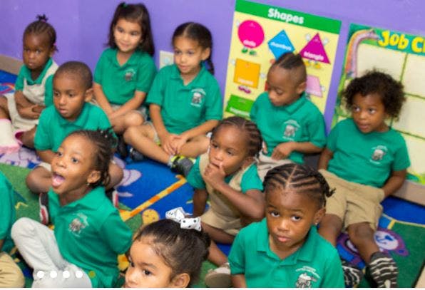 Group of children sitting on the floor in a classroom