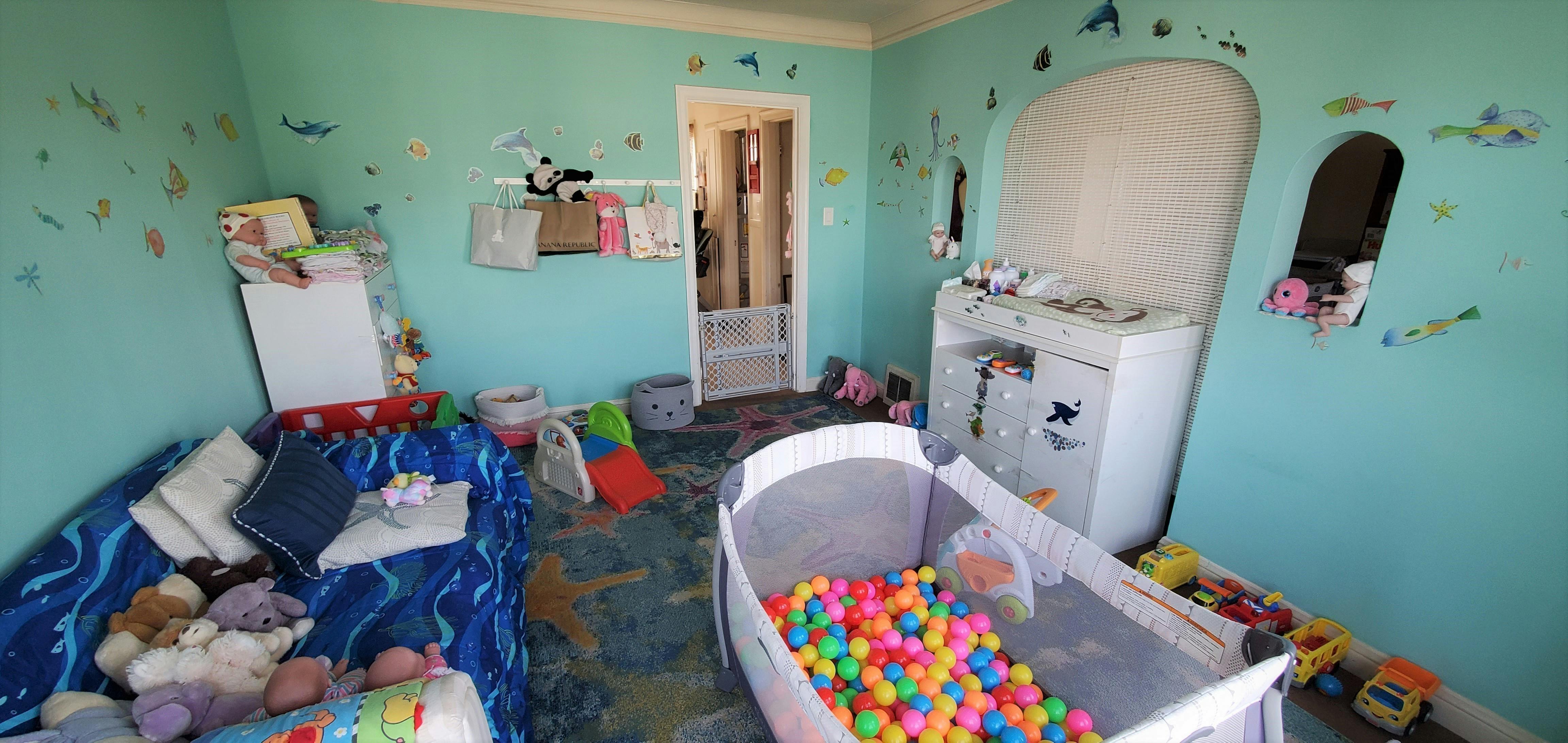 Child's room with a ball pit, toys, and a changing table