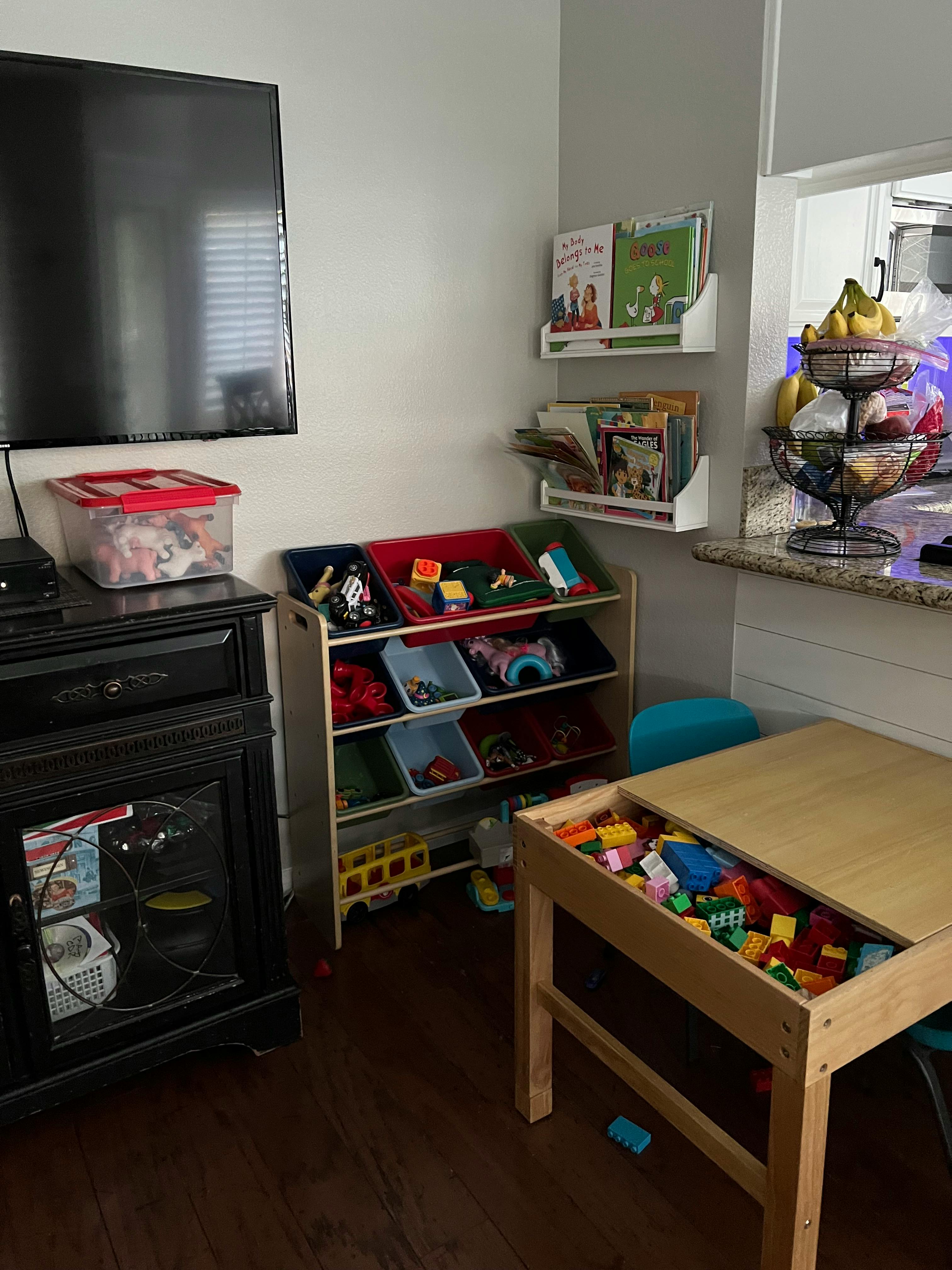 Living area with a television, toy storage, and a play table with building blocks