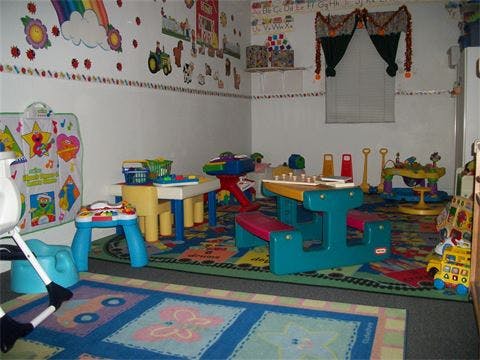 Playroom with colorful rugs, small tables, and chairs
