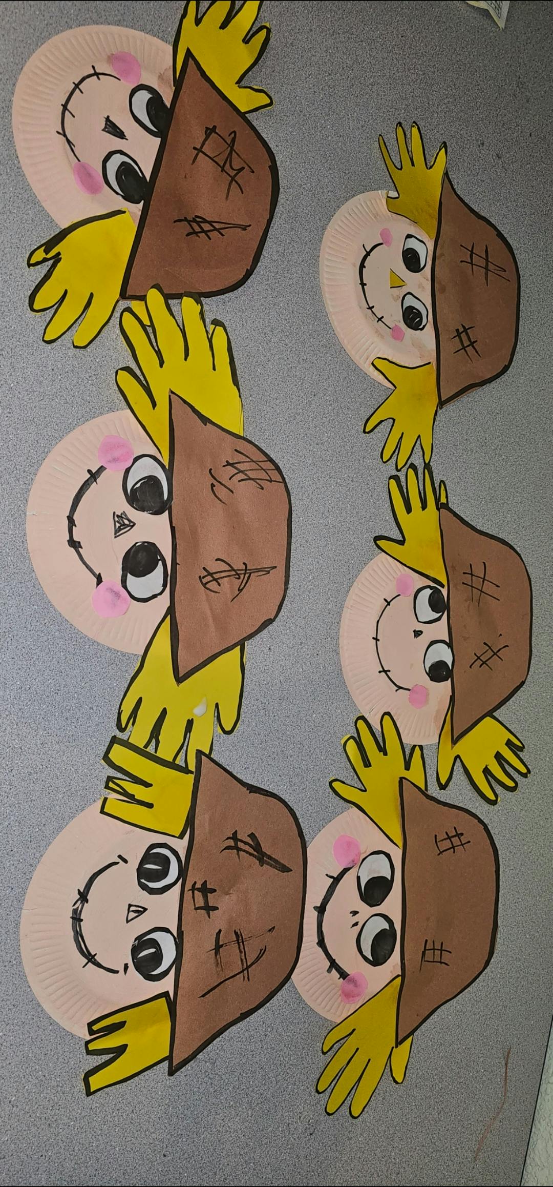 Paper plate scarecrow crafts with yellow handprint hair