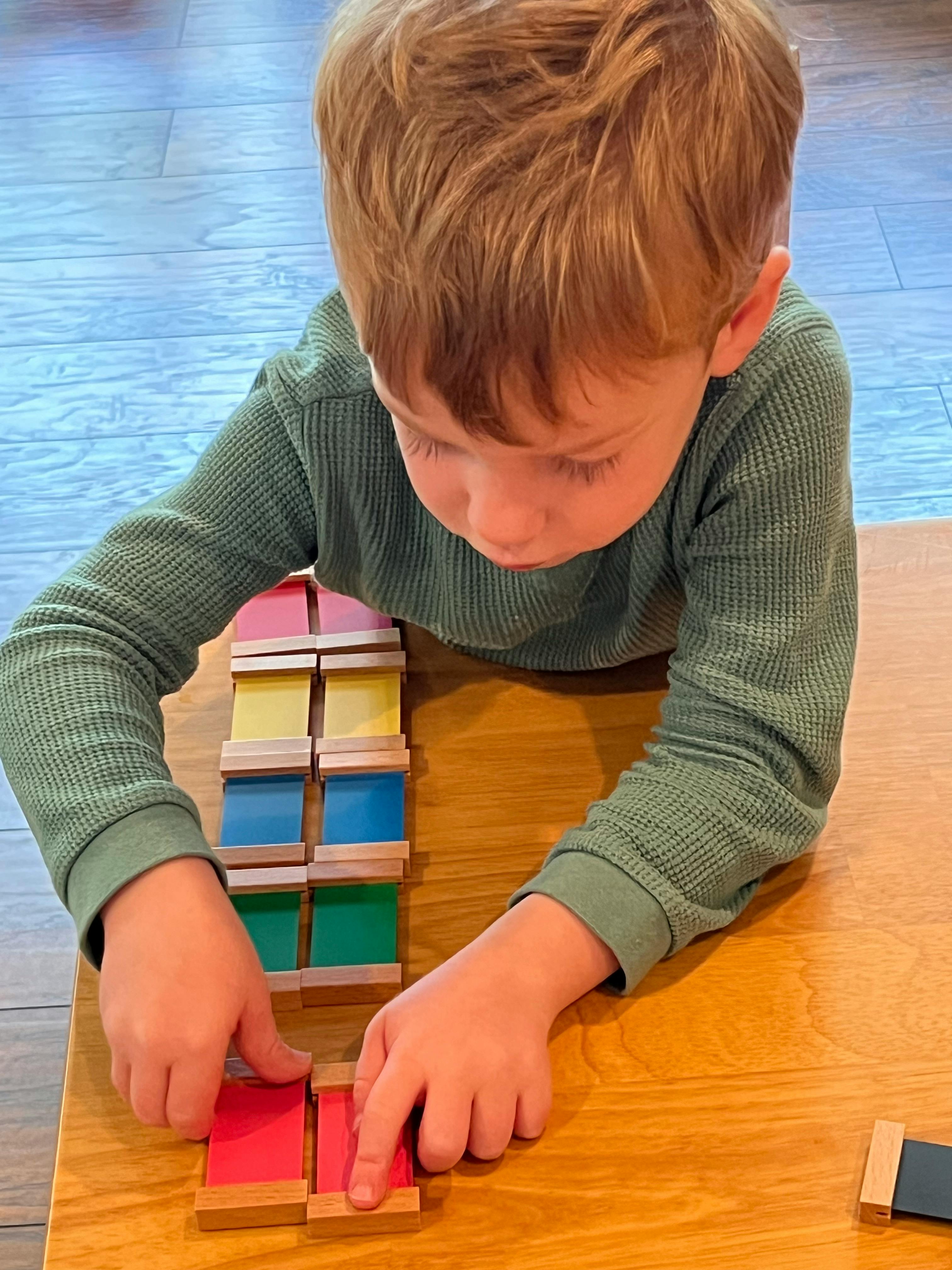 Child playing with colorful wooden blocks on a table