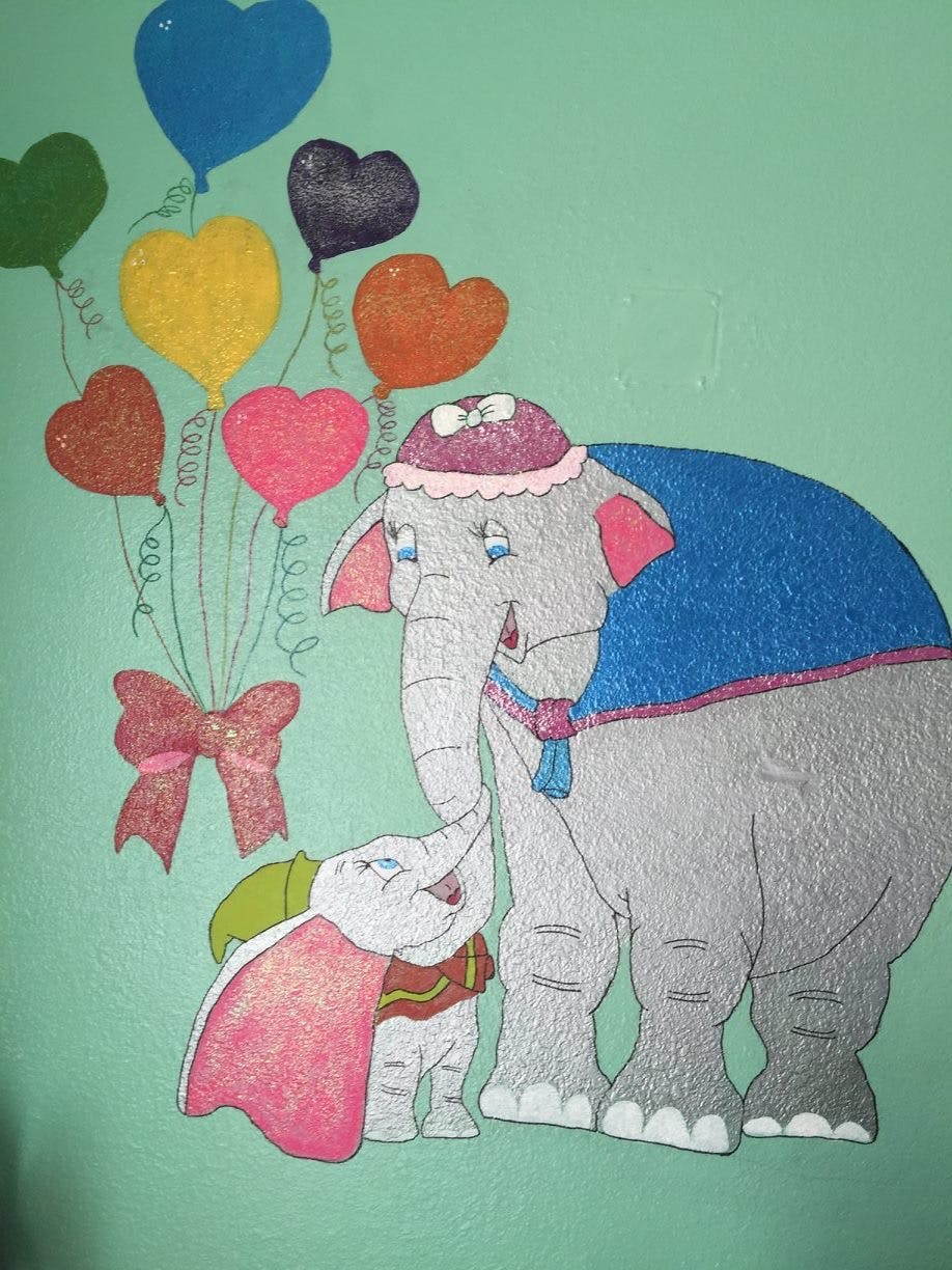Two elephants with heart-shaped balloons and a bow