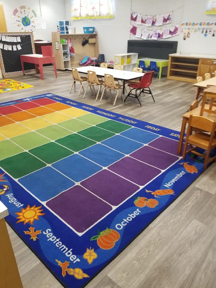 Classroom with a colorful rug and small tables and chairs