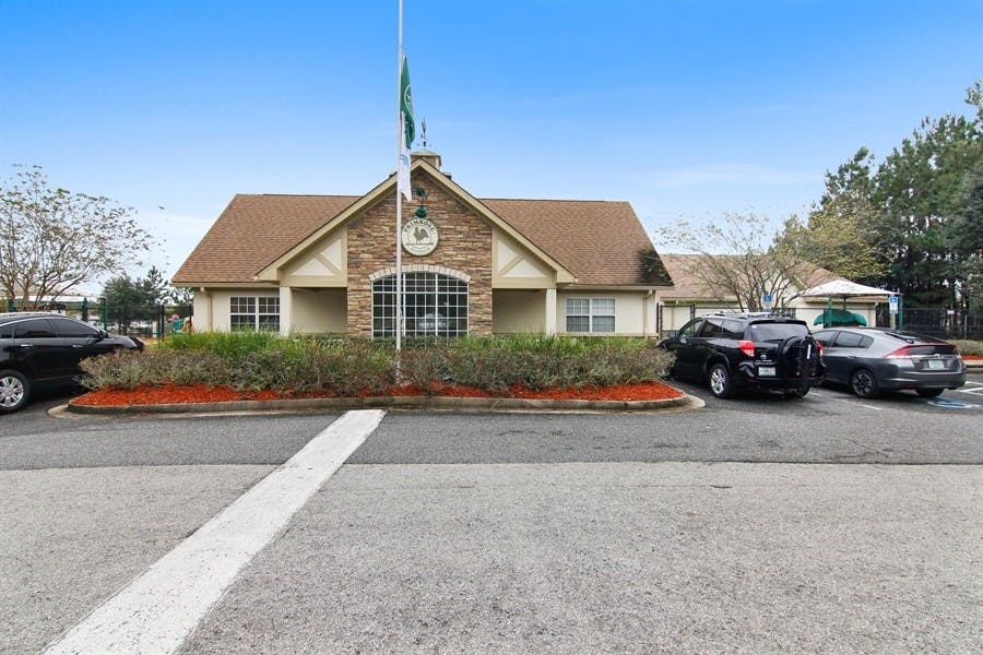 Building with a flag pole in front and cars parked on the side