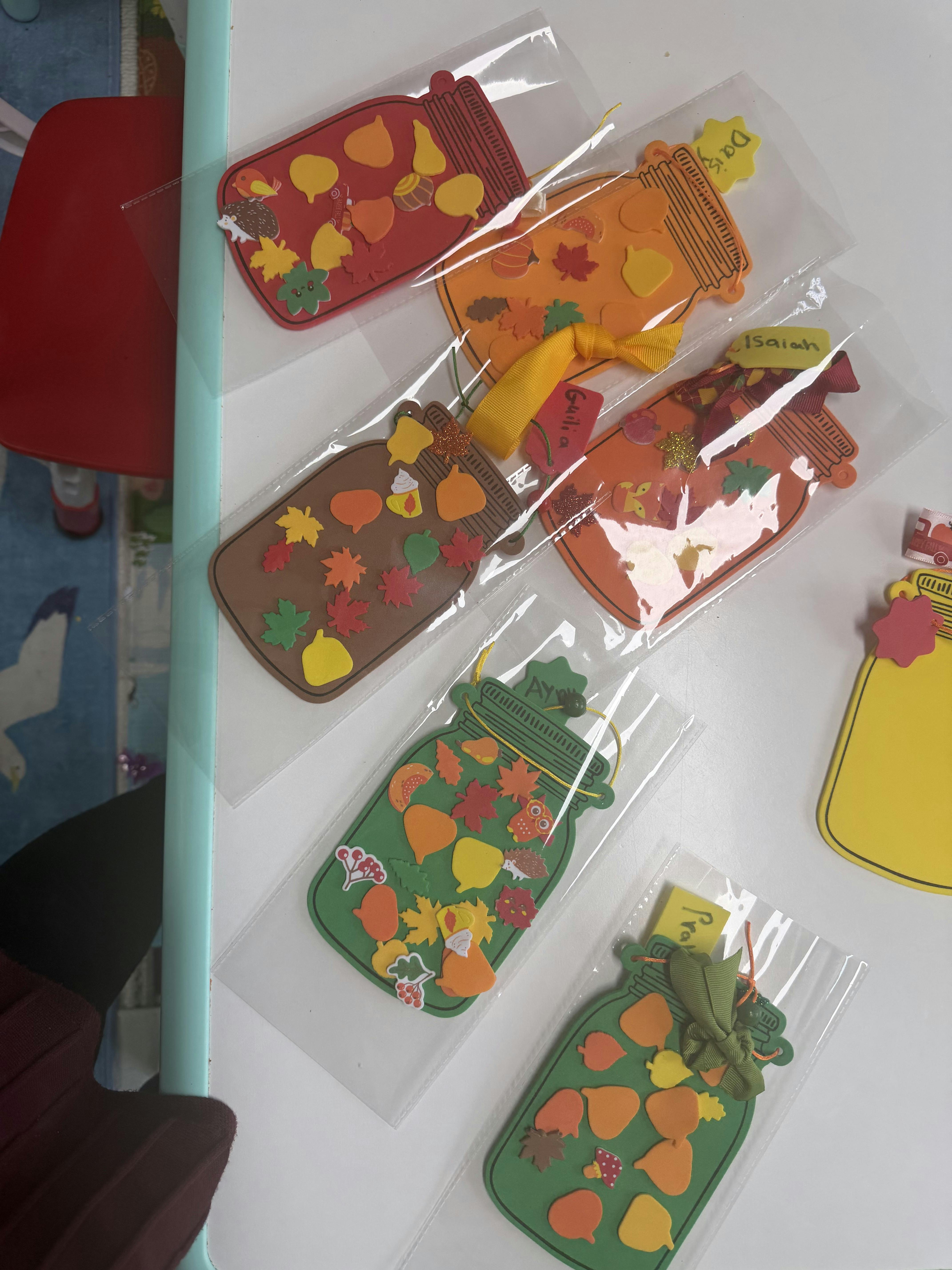 Handmade paper mason jar crafts decorated with foam fall shapes in plastic bags