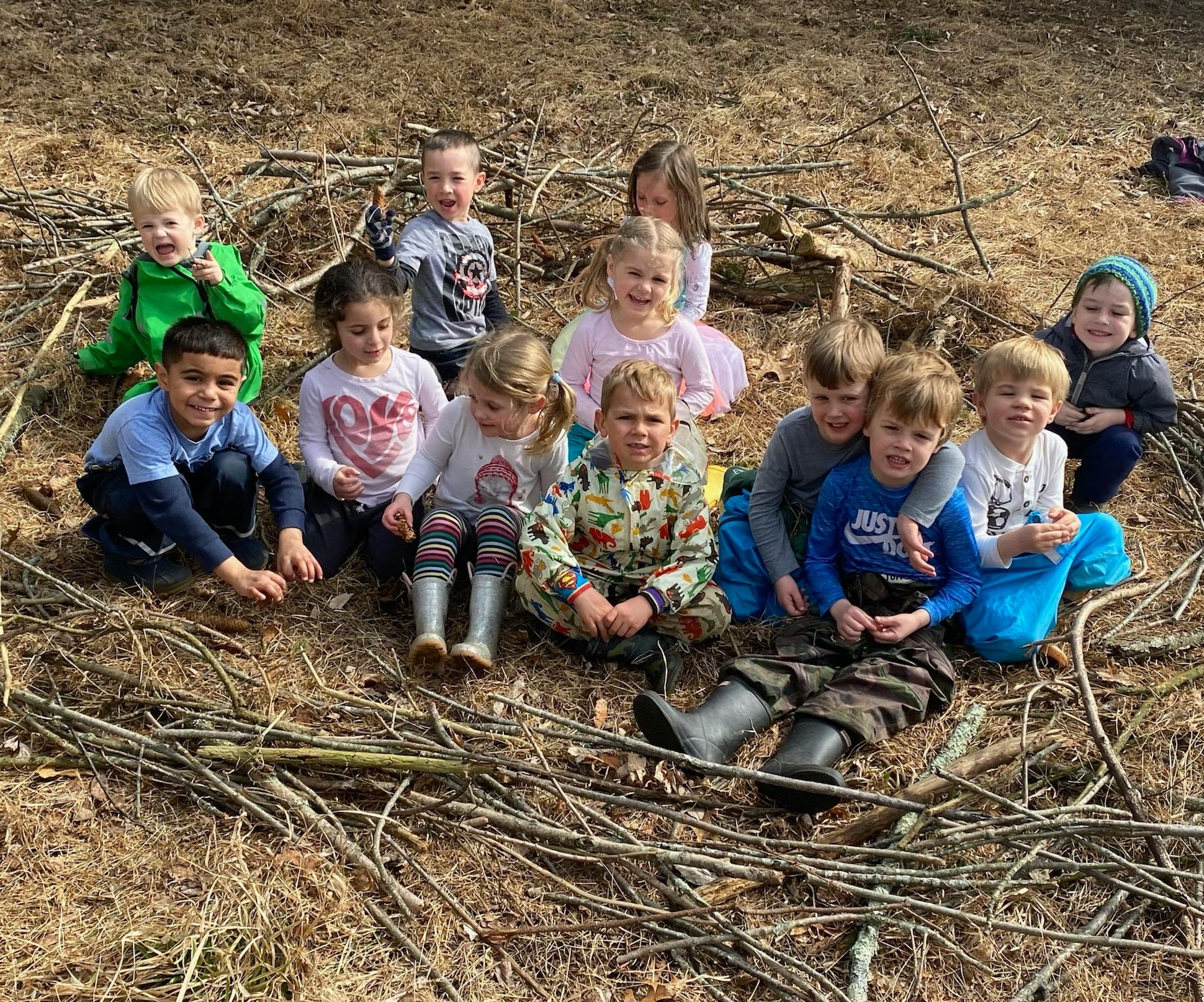 Group of children sitting on the ground outdoors