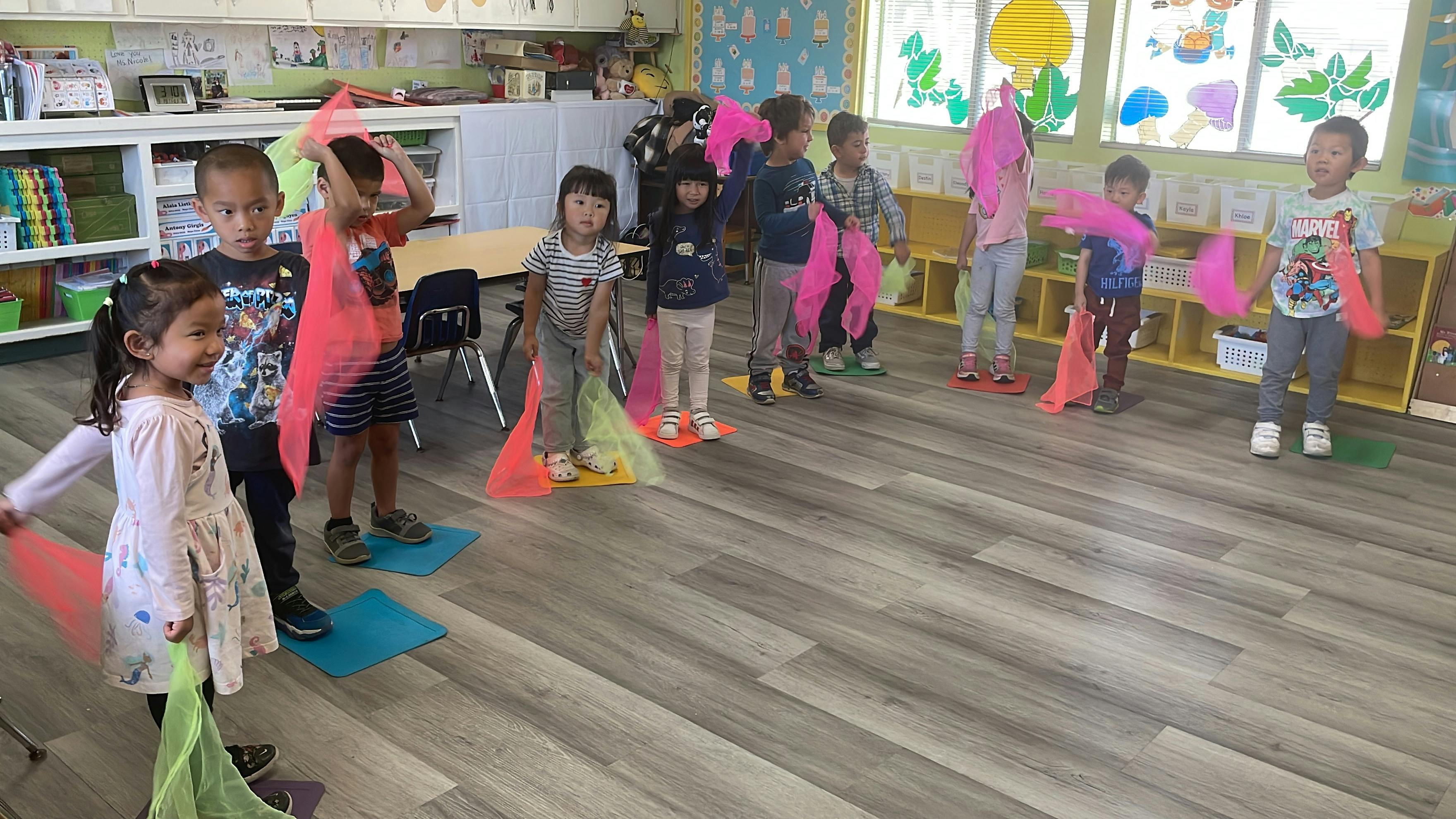 Children in a classroom holding colorful scarves