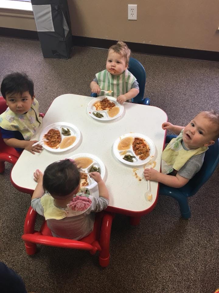 Four children eating at a small table
