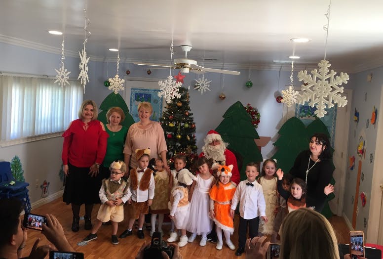 Adults and children in costumes posing with a person dressed as Santa Claus