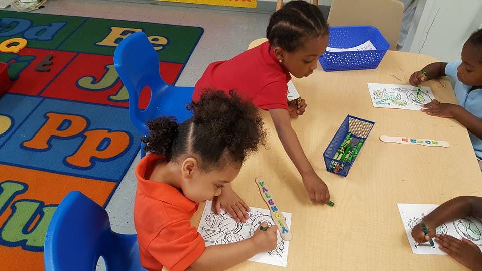 Children coloring at a table in a classroom