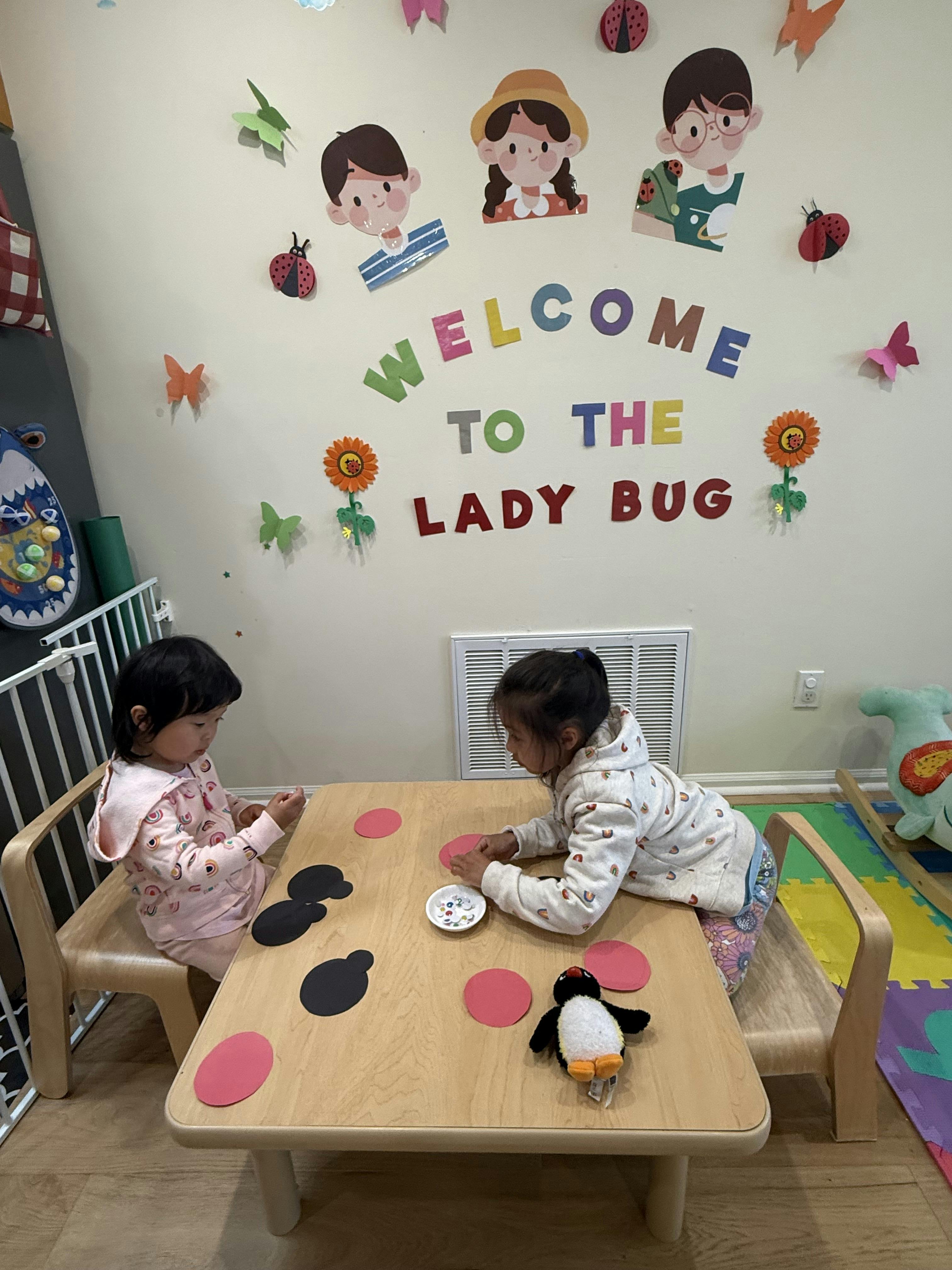 Two children playing with paper cutouts at a table