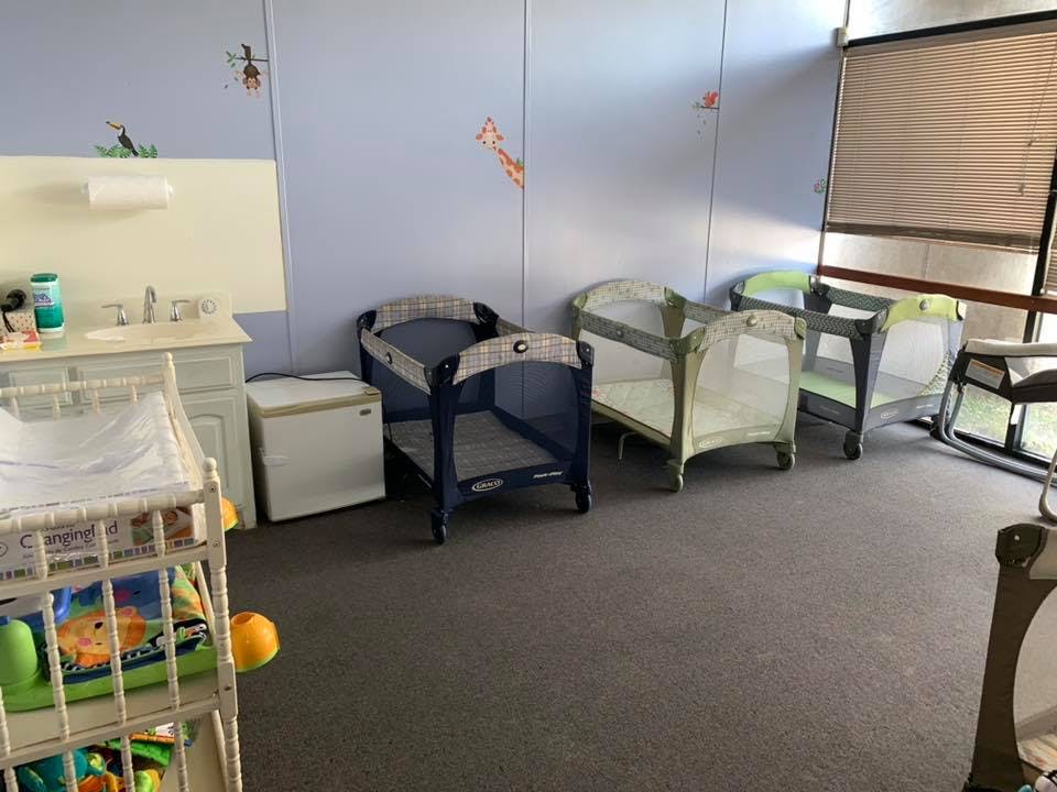 Multiple portable cribs in a room with a changing station