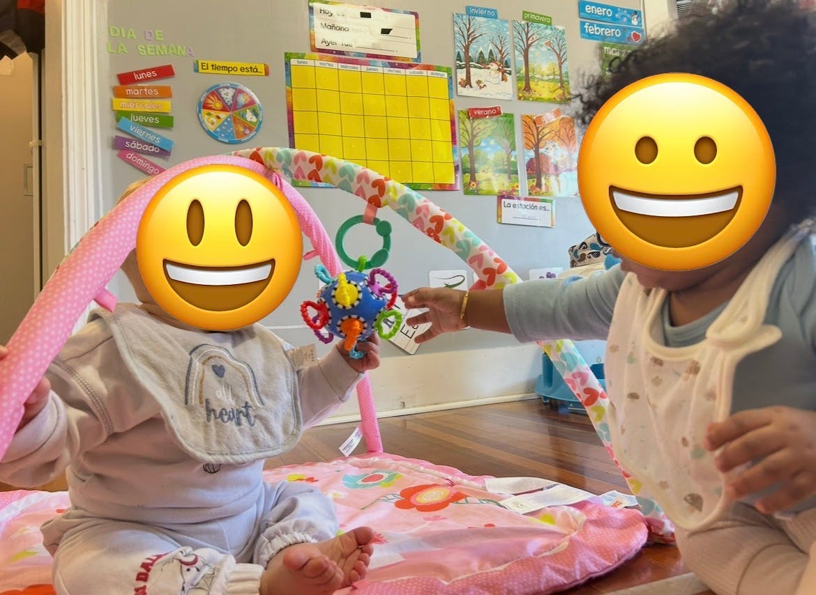 Two children playing with a baby gym toy