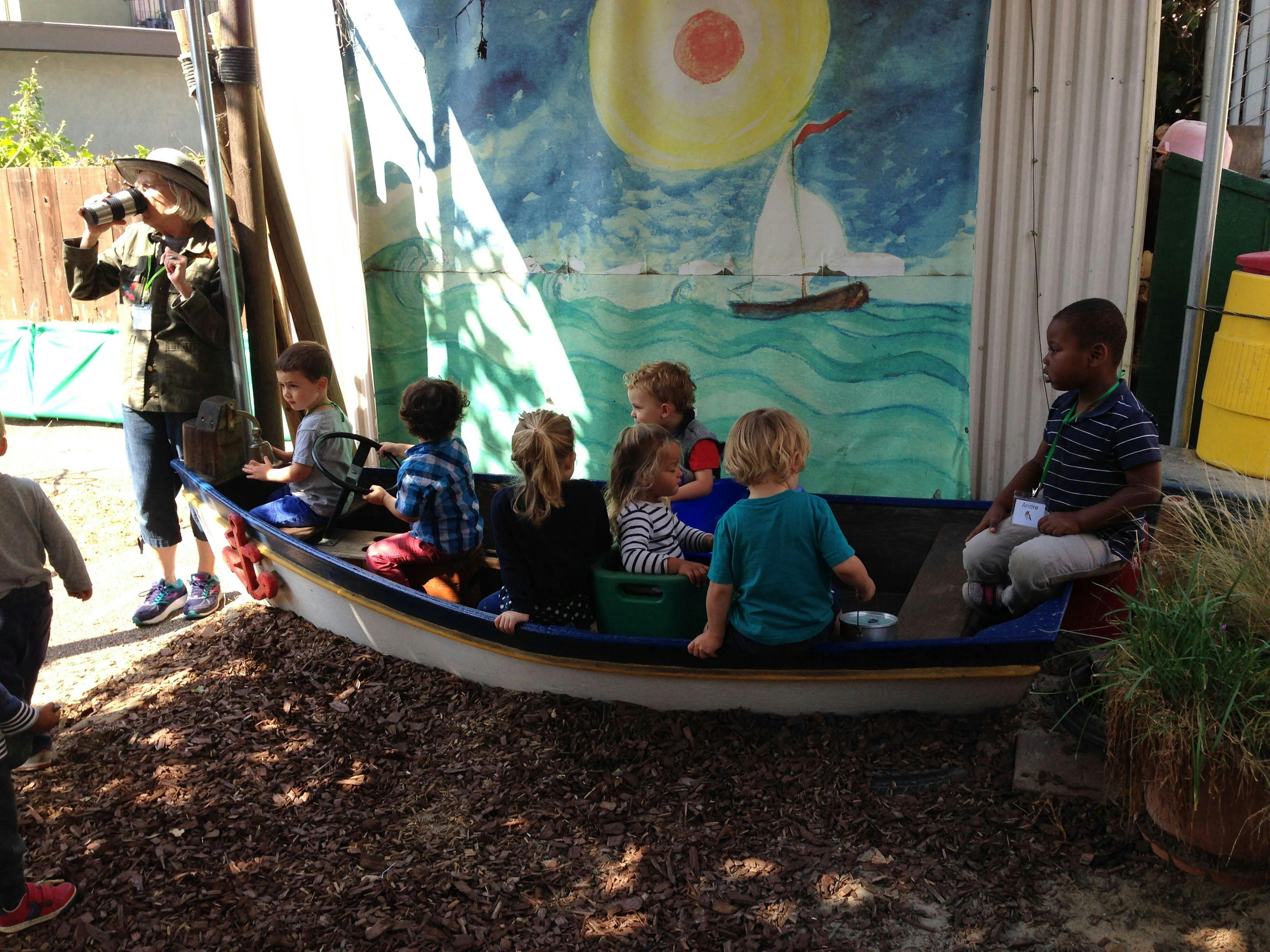 Children sitting in a boat-shaped play structure